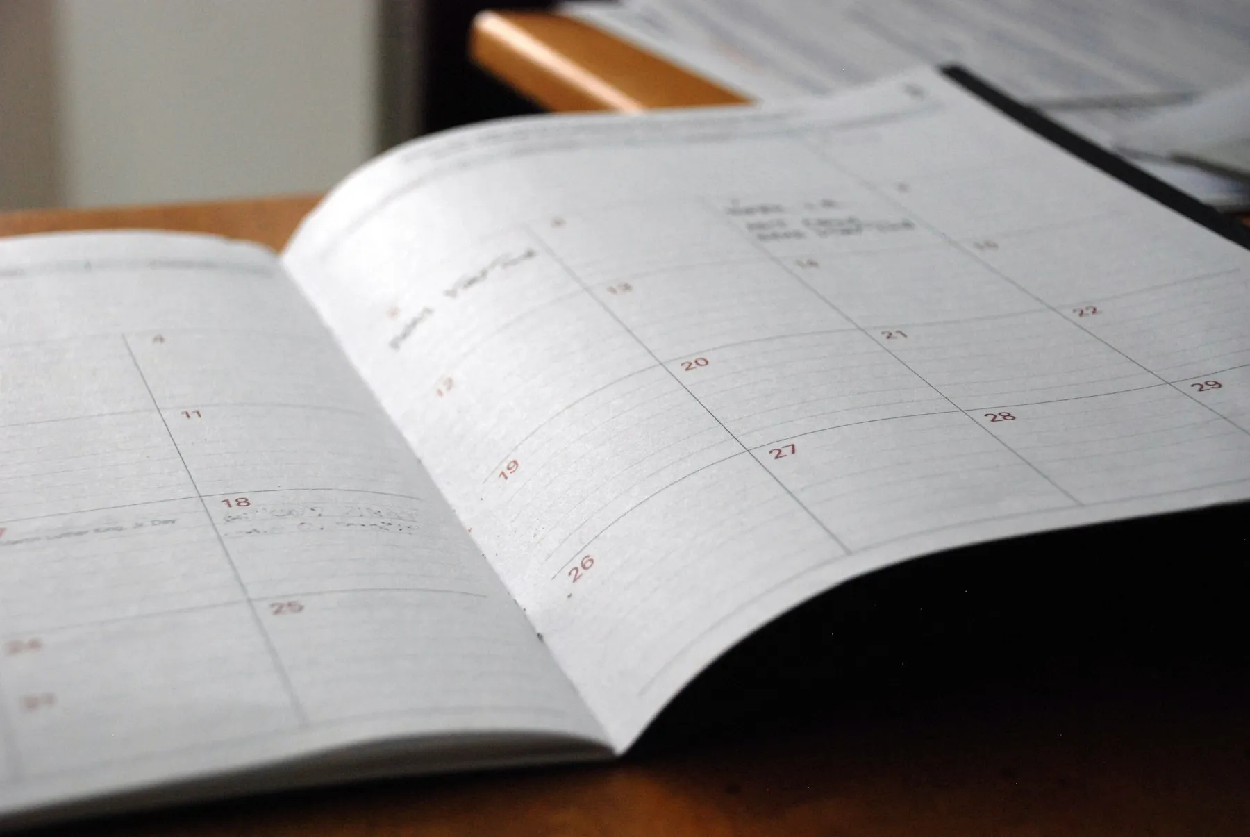 Calendrier mensuel ouvert sur un bureau en bois