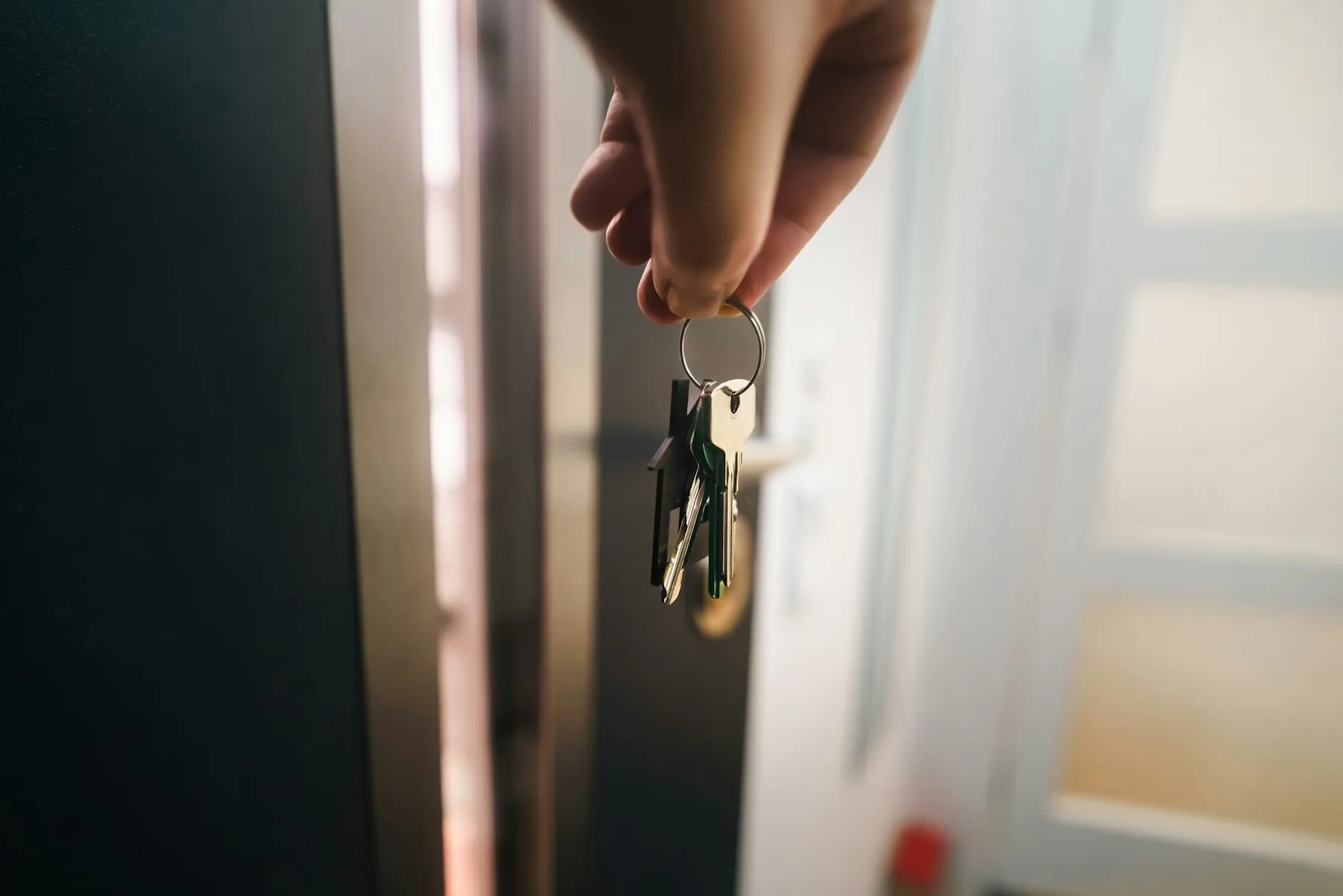 Jeu de clés tendu devant la porte d’un logement
